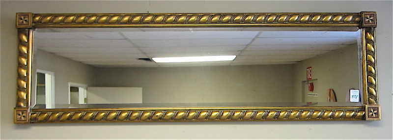 Appraisal: LONG AND NARROW BEVELED WALL MIRROR with spiral-turned half column