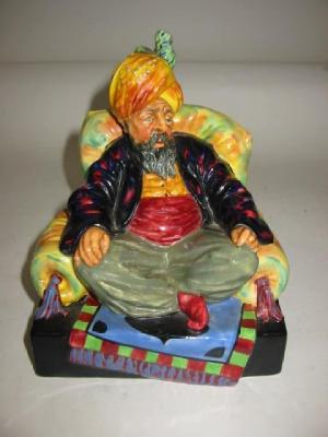 Appraisal: A ROYAL DOULTON POTTERY FIGURE Abdullah HN modelled seated on