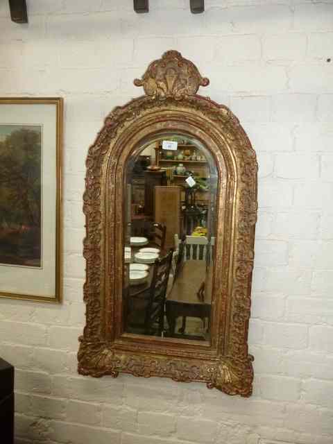 Appraisal: A GILT FRAMED WALL MIRROR with decorative crest over the