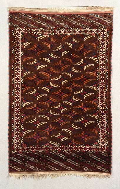 Appraisal: A YOMUT WINE GROUND RUG decorated six rows of hooked