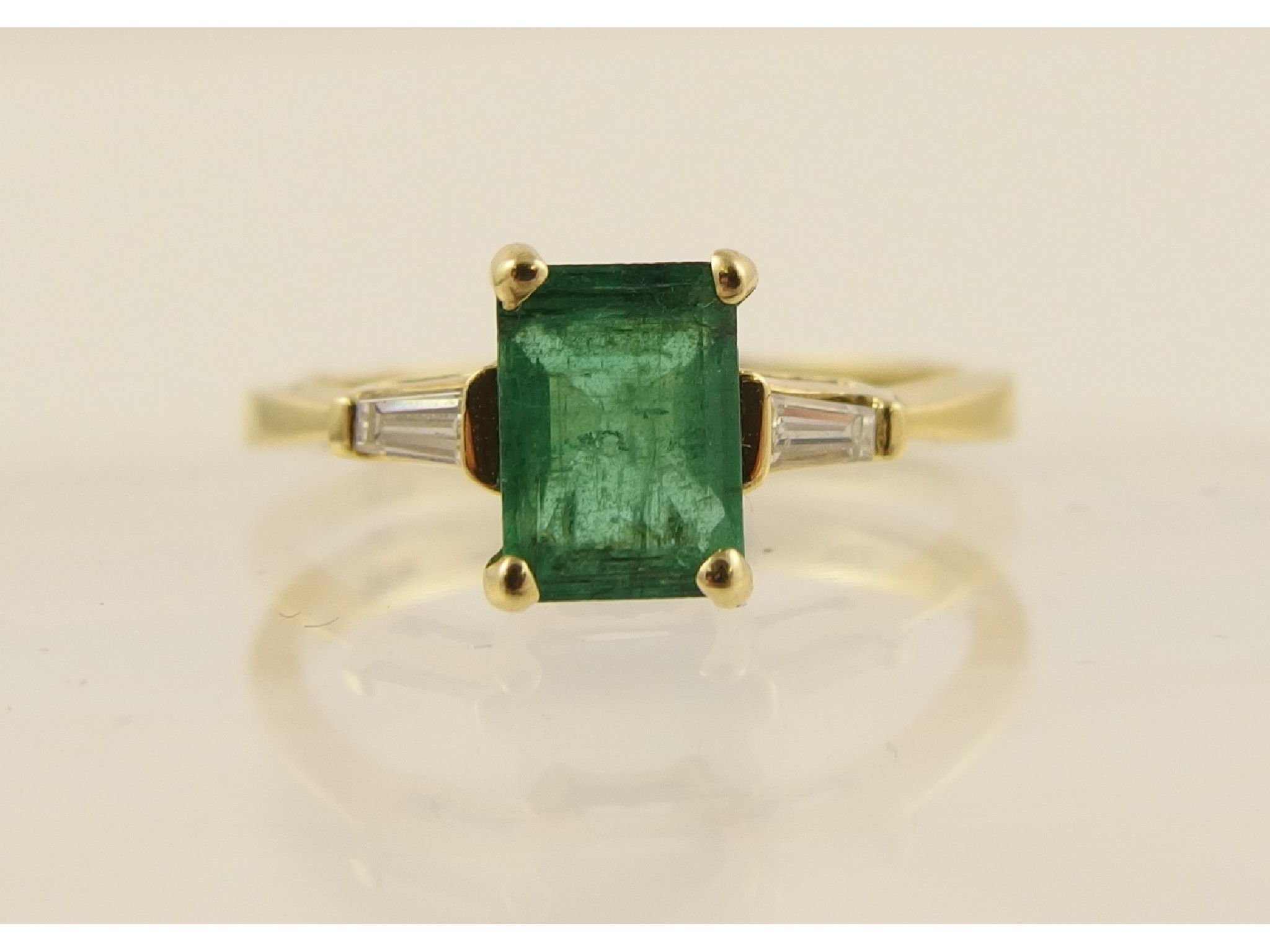 Appraisal: An ct yellow gold step cut emerald and baguette cut