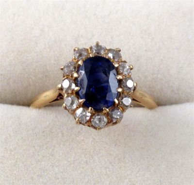 Appraisal: A sapphire and diamond cluster ring The oval shaped sapphire