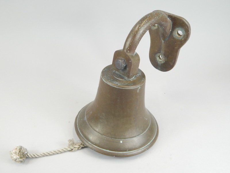 Appraisal: A wall mounted brass bell with hinged bracket