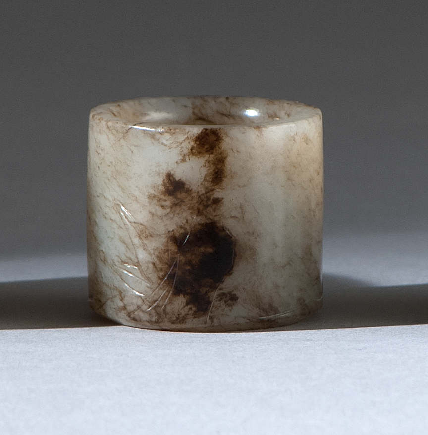 Appraisal: BROWN AND WHITE JADE THUMB RING Late th CenturyWith incised