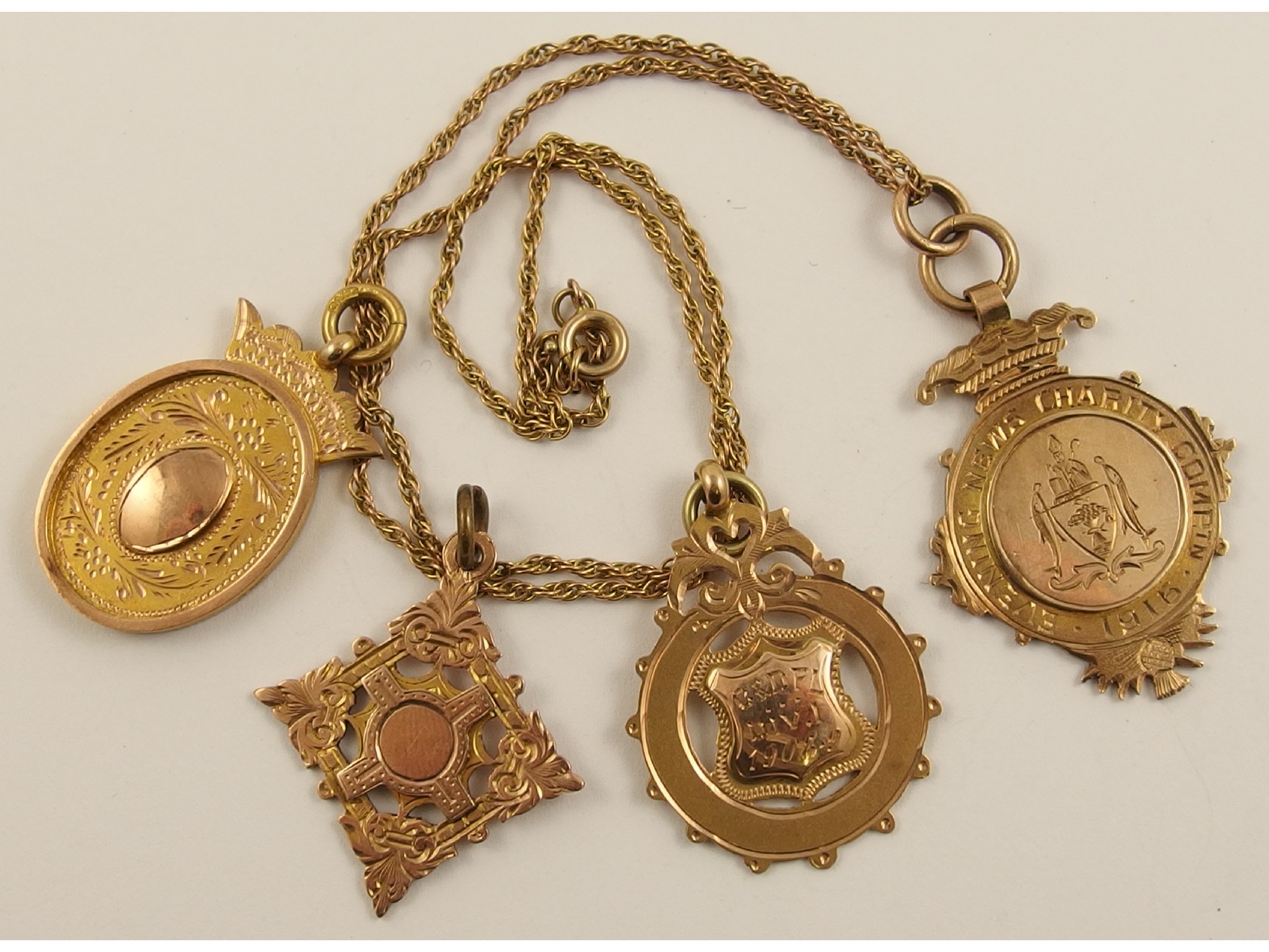 Appraisal: Four ct medallions one with a yellow metal chain approx