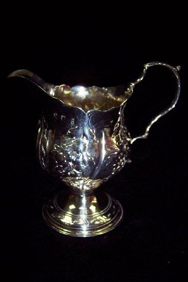 Appraisal: A George III cream jug of urn form embossed with