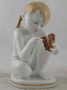 Appraisal: A Soviet Russian ceramic figure of a young girl squatting