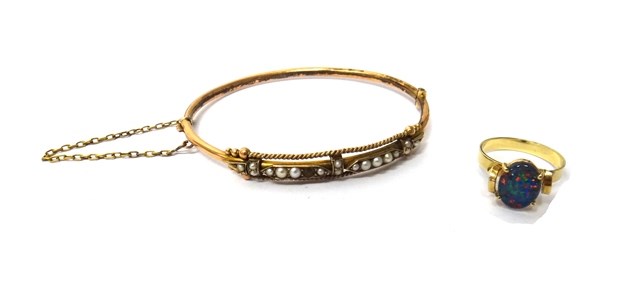 Appraisal: A gold and seed pearl set oval hinged bangle on