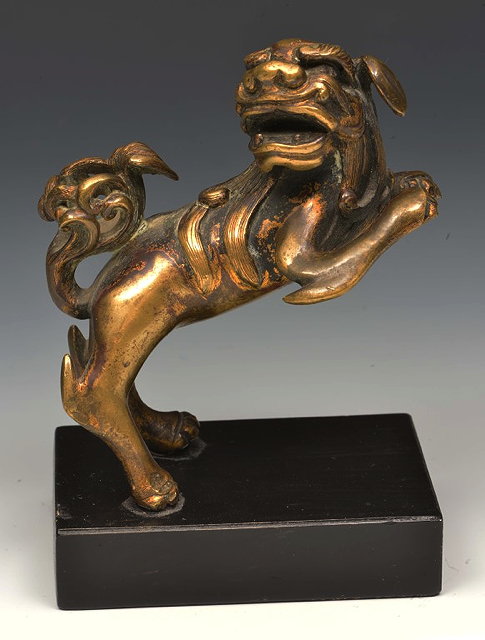 Appraisal: A CHINESE BRONZE TEMPLE DOG in an aggressive stance on