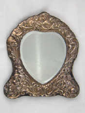 Appraisal: A silver faced heart shaped mirror the frame with cupids