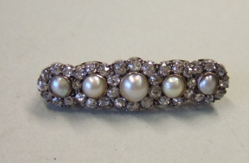 Appraisal: A diamond and half pearl set brooch designed as a