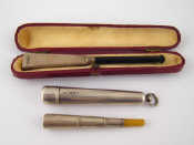 Appraisal: A white metal untested telescoping cigarette holder with composition mouthpiece