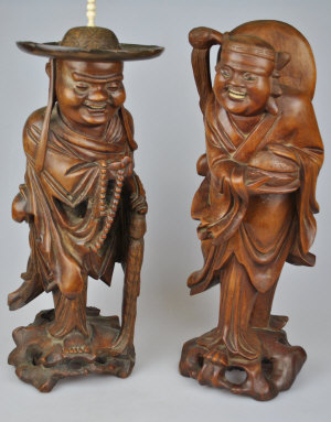 Appraisal: Two Chinese carved standing wood figures one holding a string