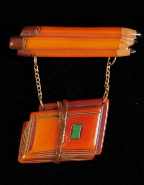 Appraisal: Bakelite Pencils with Suspended Books Pin Description Rare Condition Near