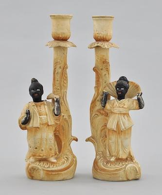 Appraisal: A Pair of Blackamoor Nodder Bisque Candlesticks Both bisque porcelain