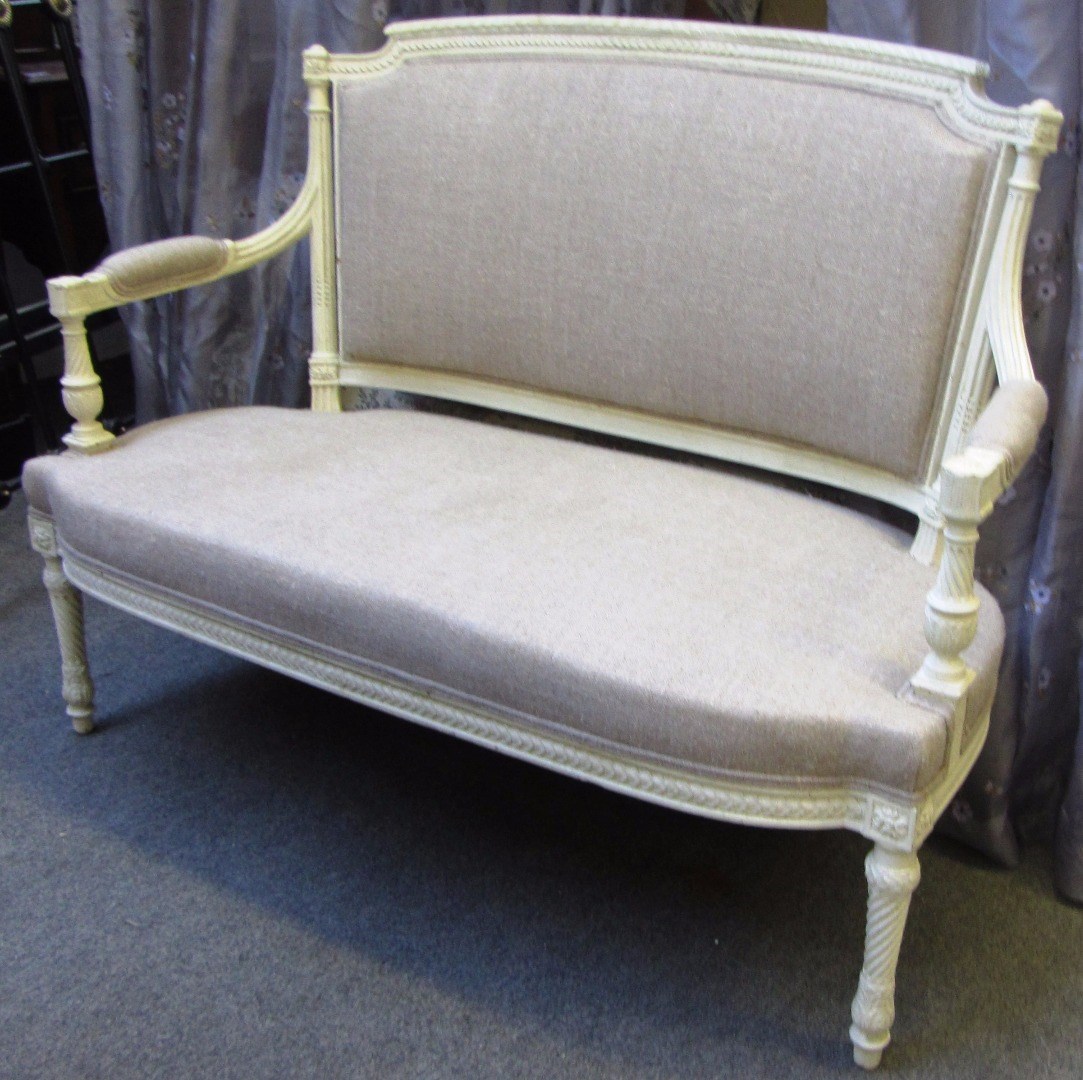 Appraisal: A Louis XVI style cream painted sofa with semi-padded open