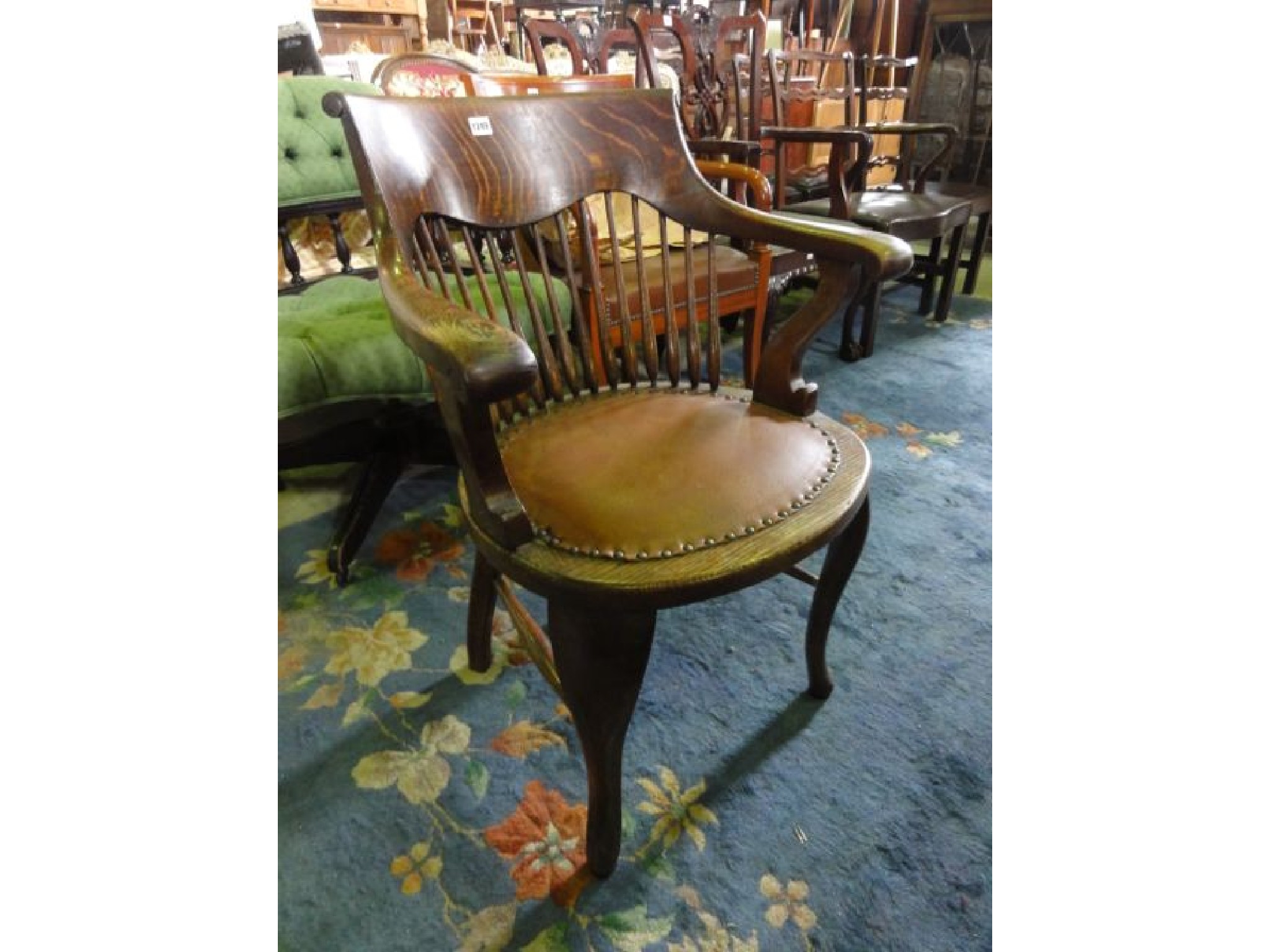 Appraisal: An Edwardian oak desk chair the bowed turned spindle back