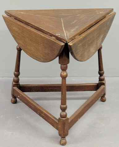 Appraisal: English oak triangular tap table with fold-down leaves and turned