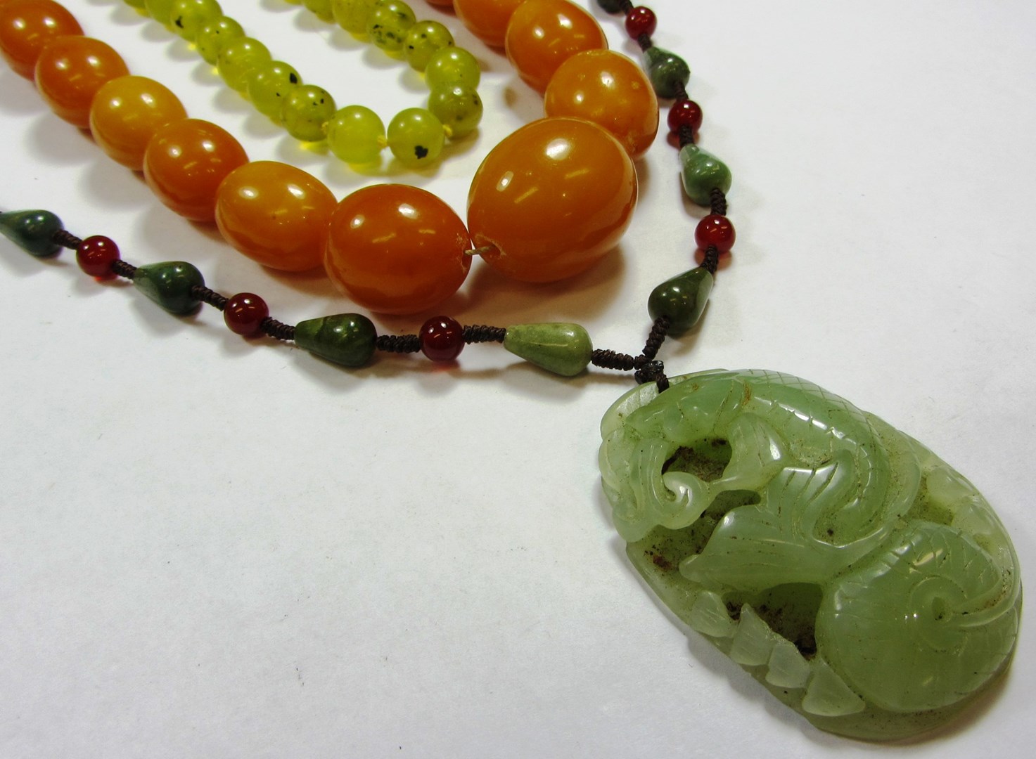 Appraisal: A single row necklace of reconstituted amber beads graduating in