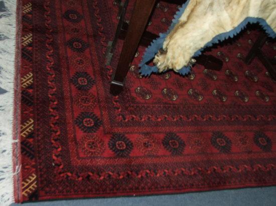 Appraisal: A BOKHARA STYLE WINE GROUND CARPET - decorated seven rows