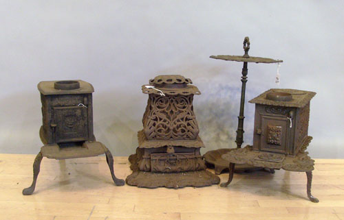 Appraisal: Three cast iron parlor stoves th c together with an