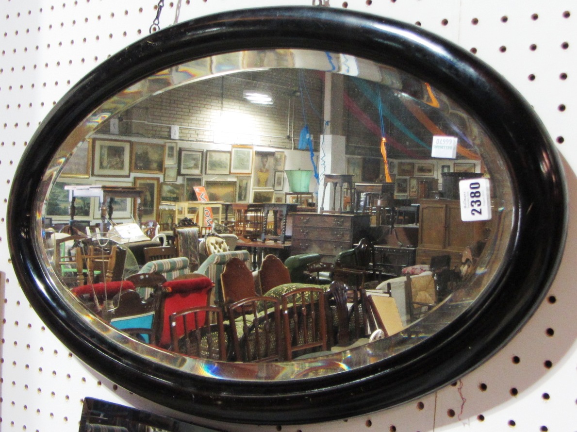 Appraisal: A th century ebonised oval mirror and a walnut towel