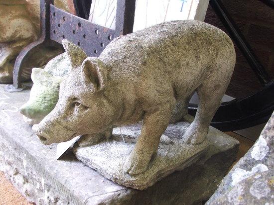 Appraisal: A WEATHERED COMPOSITION MODEL of a pig on naturalistic base