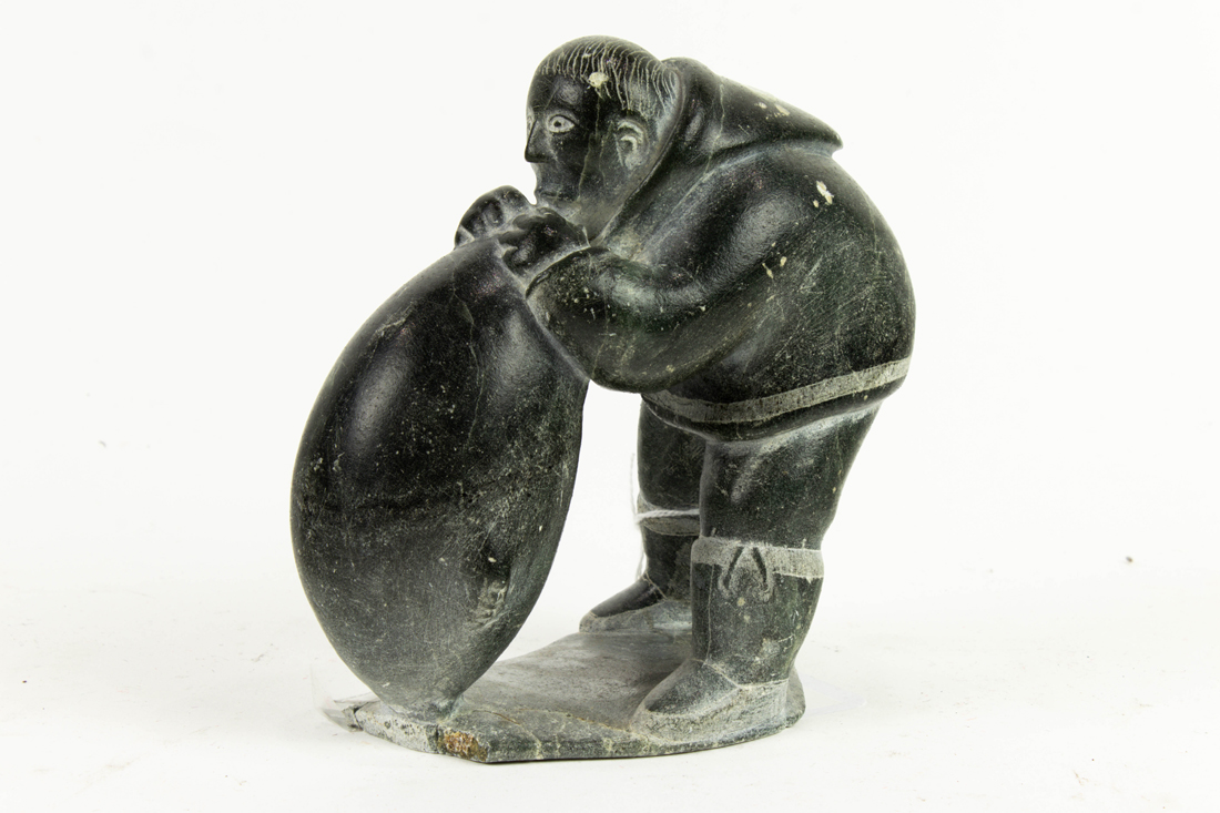 Appraisal: INUIT STONE CARVING OF A MAN AND SEAL Inuit stone