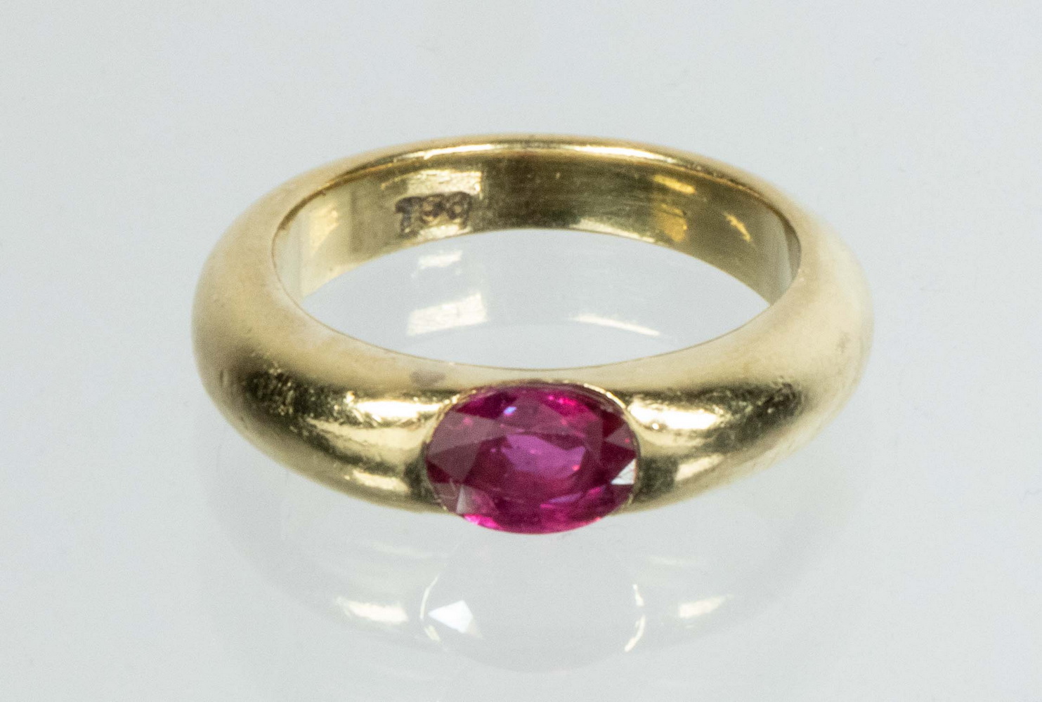 Appraisal: LADIES K GOLD AND RUBY RING Open half bezel set