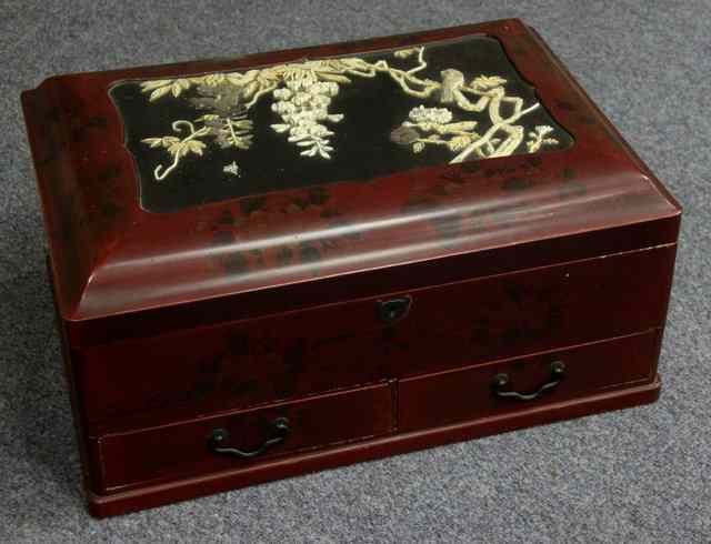 Appraisal: A Japanese red lacquer workbox with carved panel to the