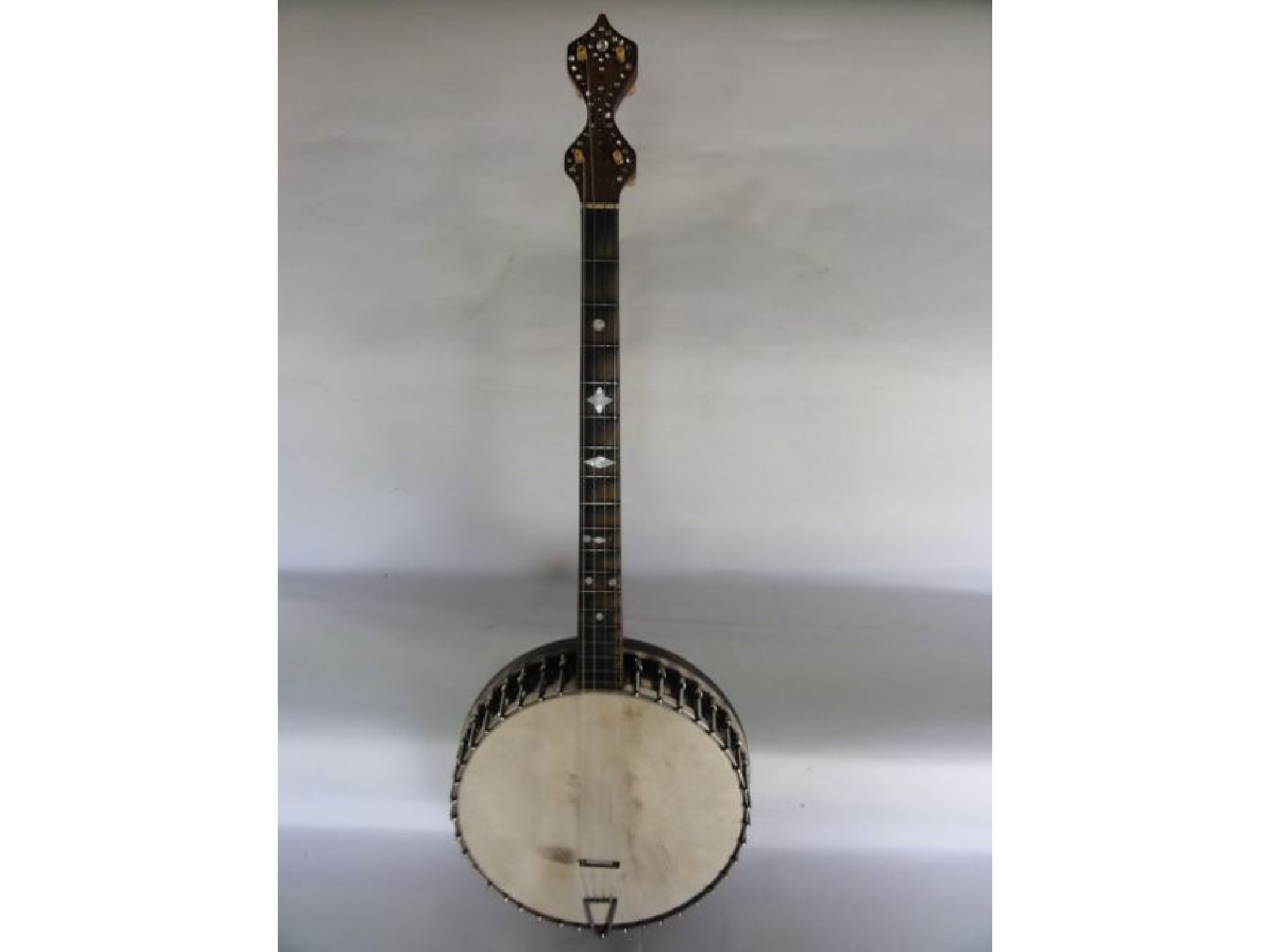 Appraisal: A four string banjo with mother of pearl inlay to