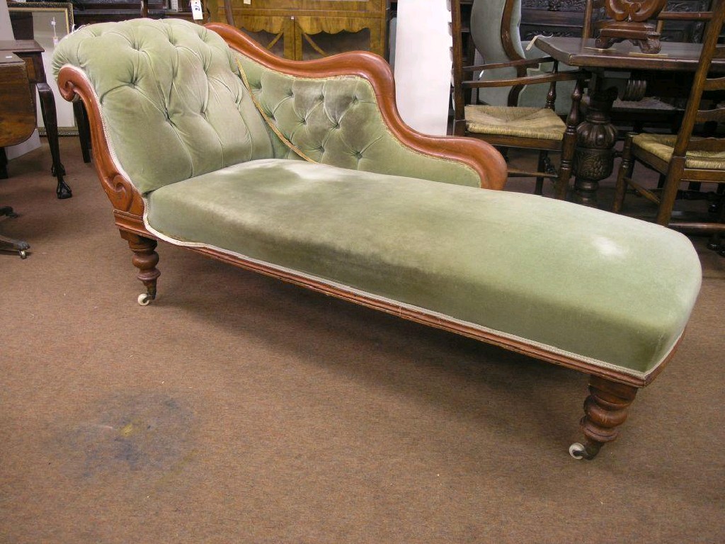 Appraisal: A Victorian stained beech chaise longue with scroll back on