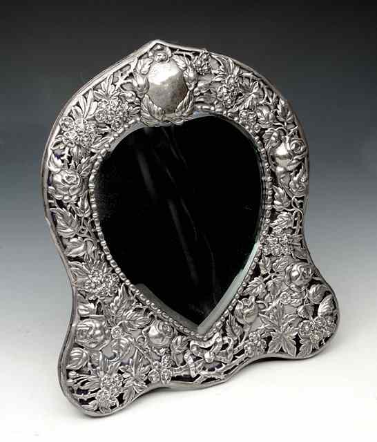 Appraisal: AN EDWARDIAN SILVER TABLE MIRROR waisted shaped with applied silver