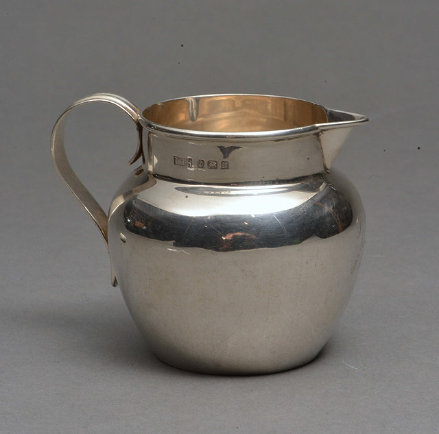 Appraisal: A SILVER BALUSTER CREAM JUG with sparrow beak and fluted