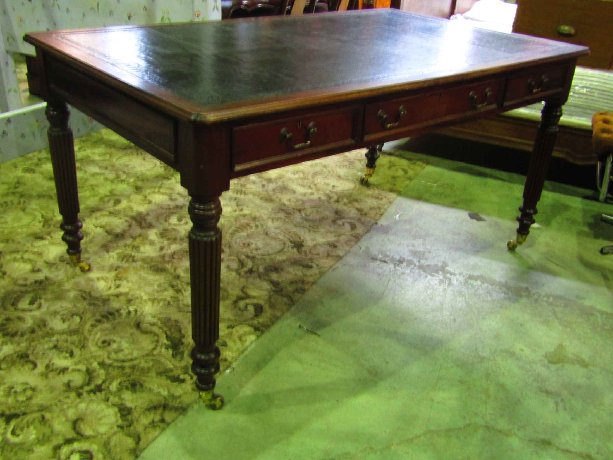 Appraisal: A reproduction mahogany library table with inset leather panel top