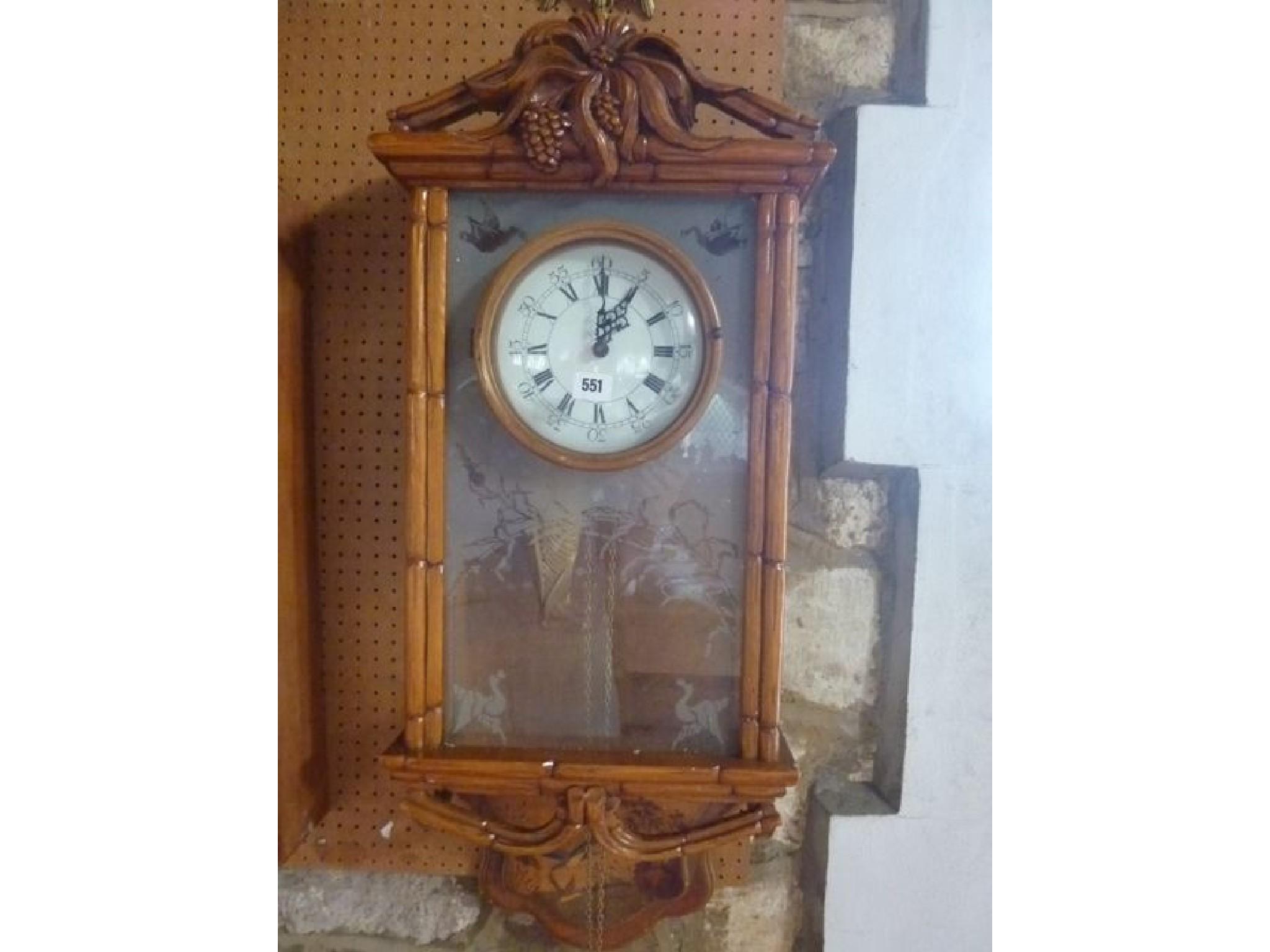 Appraisal: A continental wall clock the carved and moulded case incorporating