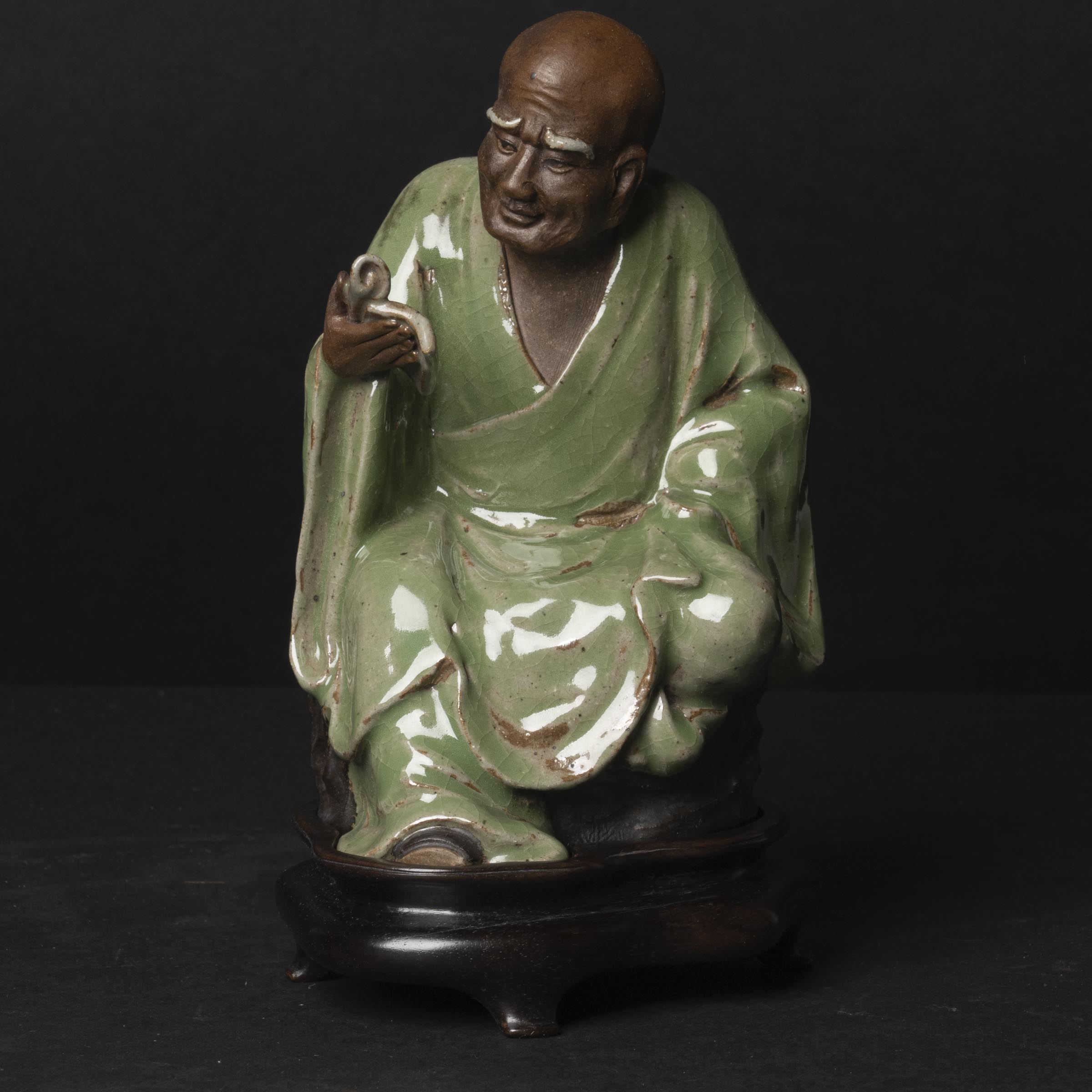 Appraisal: A Shiwan-Glazed Pottery Figure of a Luohan Qing Dynasty figure