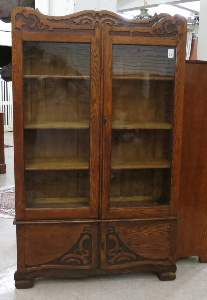 Appraisal: CARVED OAK CABINET BOOKCASE American c having three adjustable wood