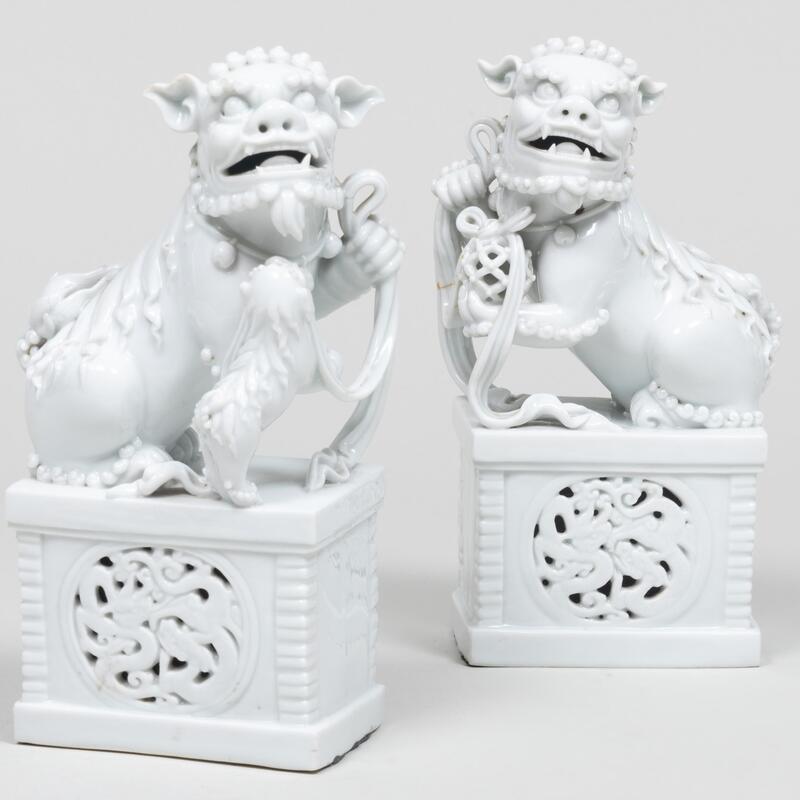 Appraisal: Pair of Chinese White Glazed Buddhist Lions on Pierced Bases