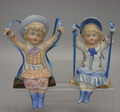 Appraisal: -Bisque Swing figurines girl boy Pair of unmarked sitting on