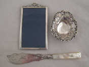 Appraisal: A silver photo frame with silver strut back and ribbon