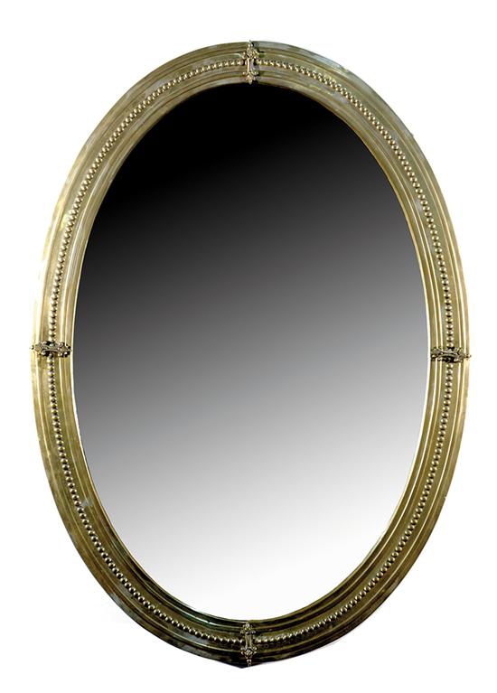 Appraisal: Oval brass looking glass molded and beaded frame enclosing beveled