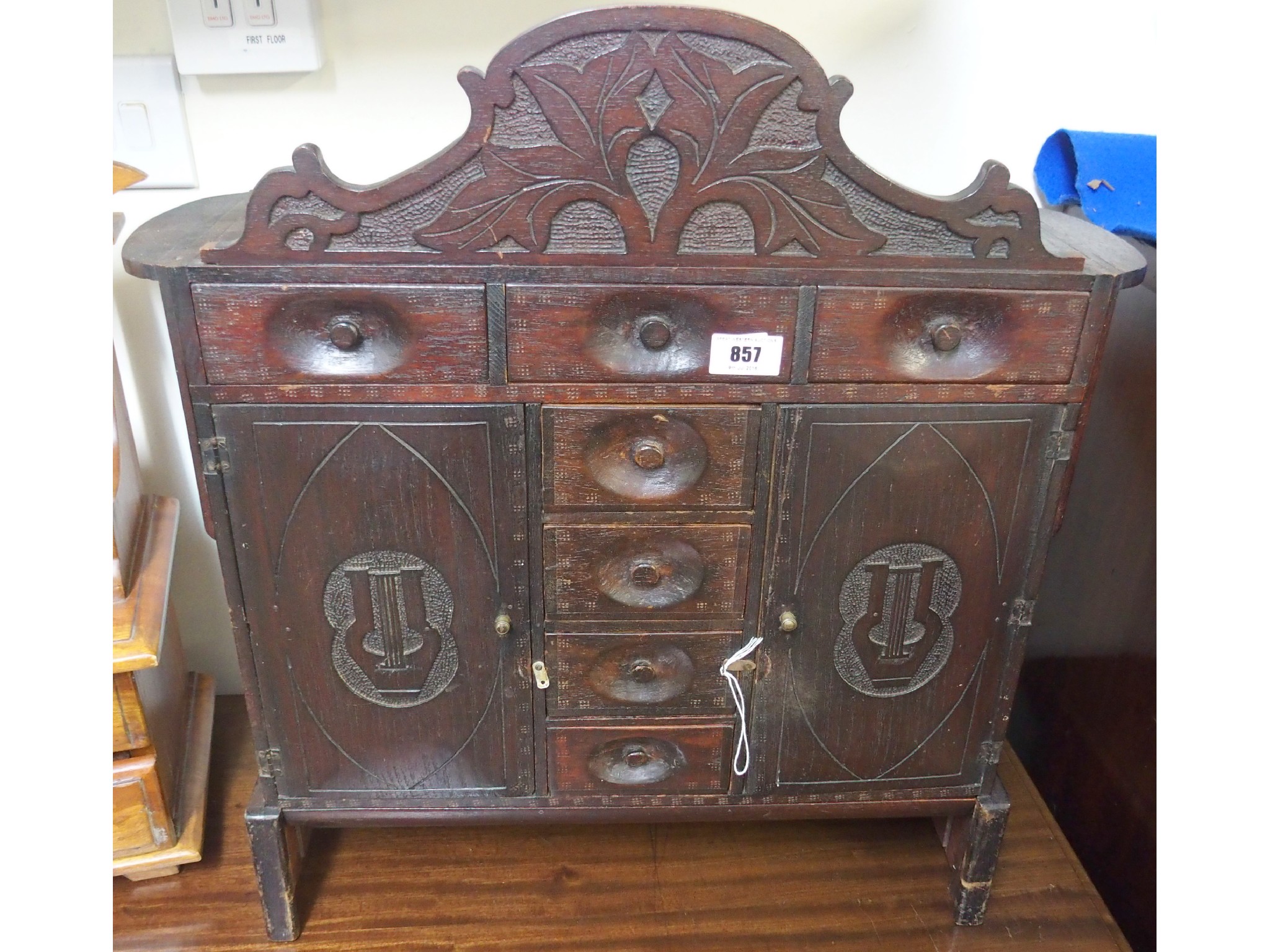 Appraisal: A small Victorian oak carved hanging cabinet with drawers and