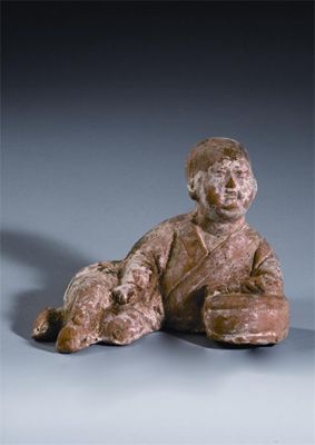 Appraisal: A Chinese unglazed pottery model of a recumbent figure leaning