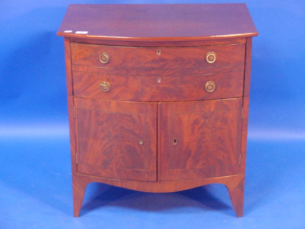 Appraisal: A small Georgian figured mahogany bow fronted cupboard fitted with