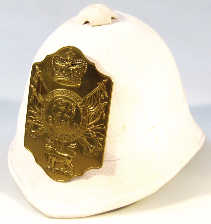 Appraisal: A thC pith helmet in white material fronted by a