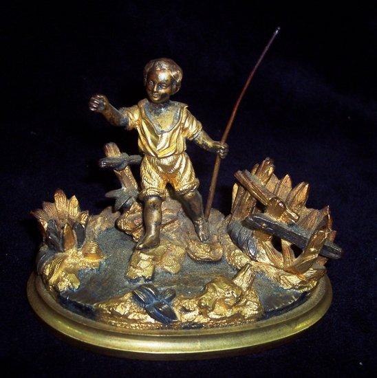 Appraisal: A bronze and gilt bronze figure of a young fisherman