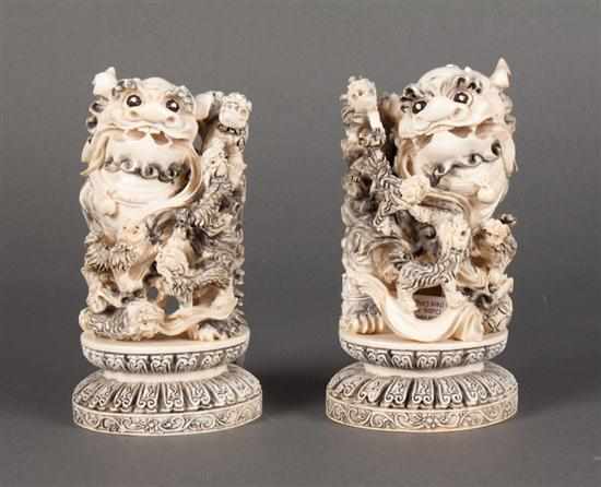 Appraisal: Pair of Chinese carved and ink-highlighted ivory foo dogs modeled