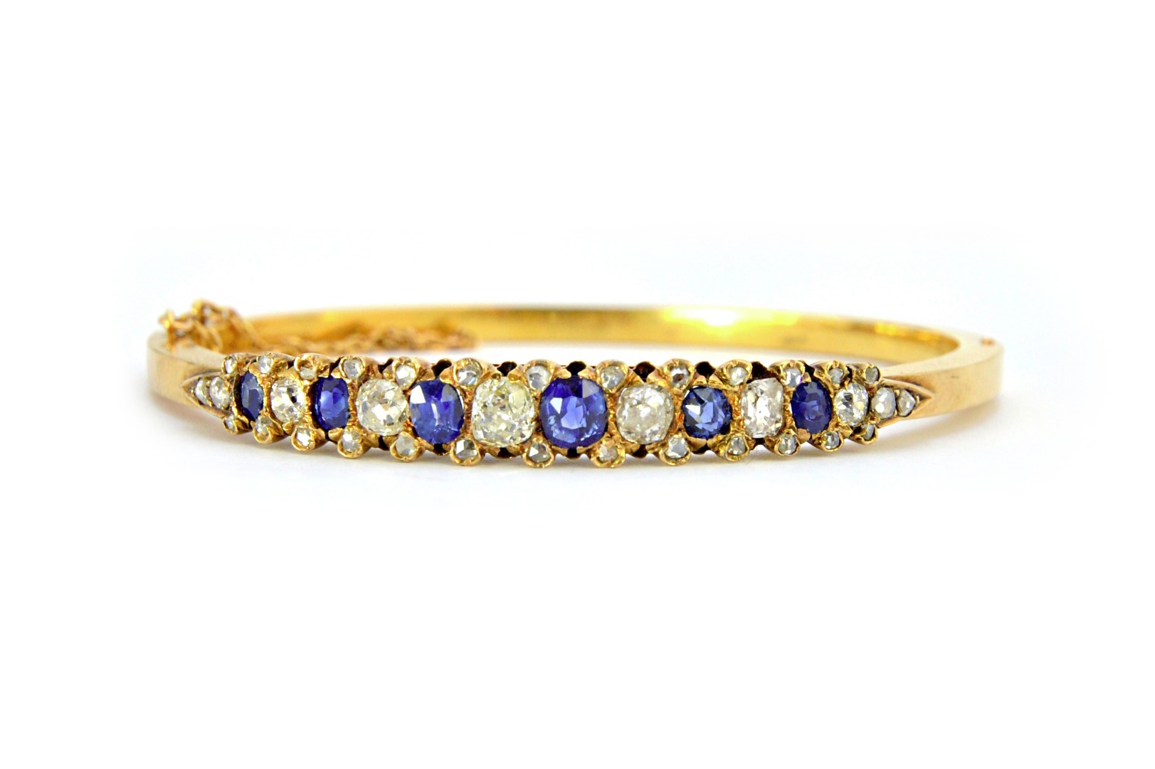 Appraisal: A gold sapphire and diamond set oval hinged bangle mounted