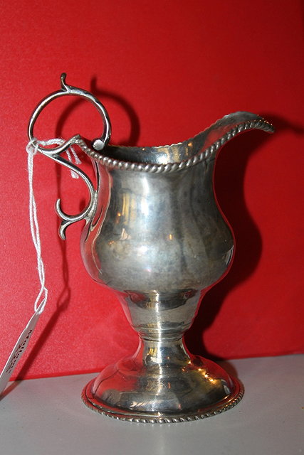 Appraisal: A GEORGIAN SILVER HELMET SHAPED CREAM JUG of baluster form